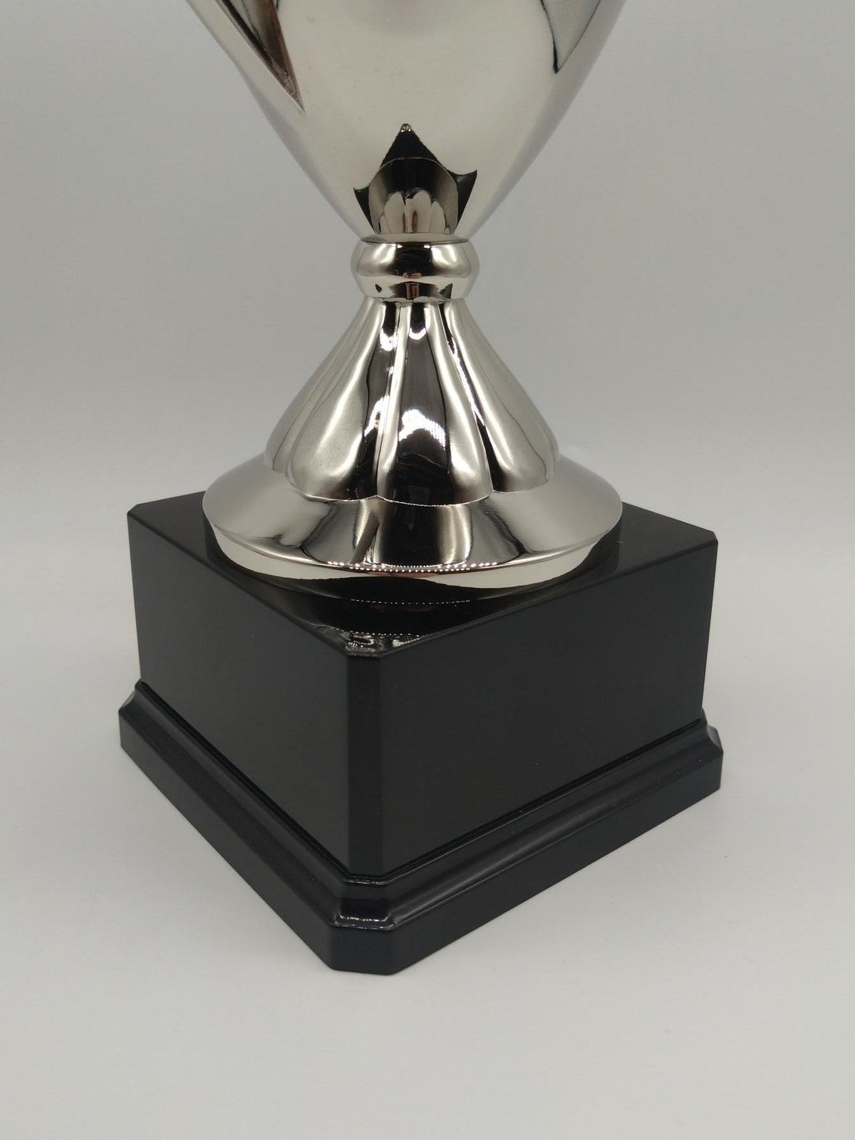 Silver trophy with a black base on a white background