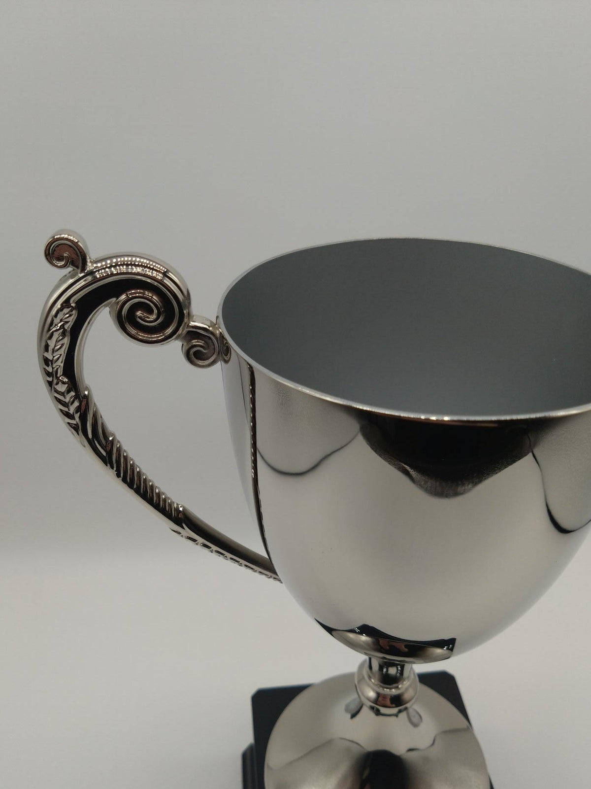 Silver trophy cup with decorative handle on a white background