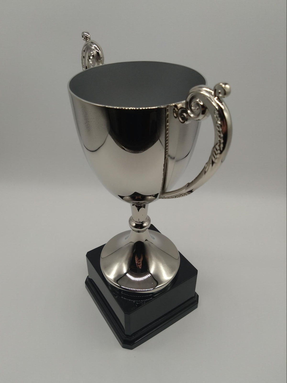 Silver trophy with a black base on a gray background