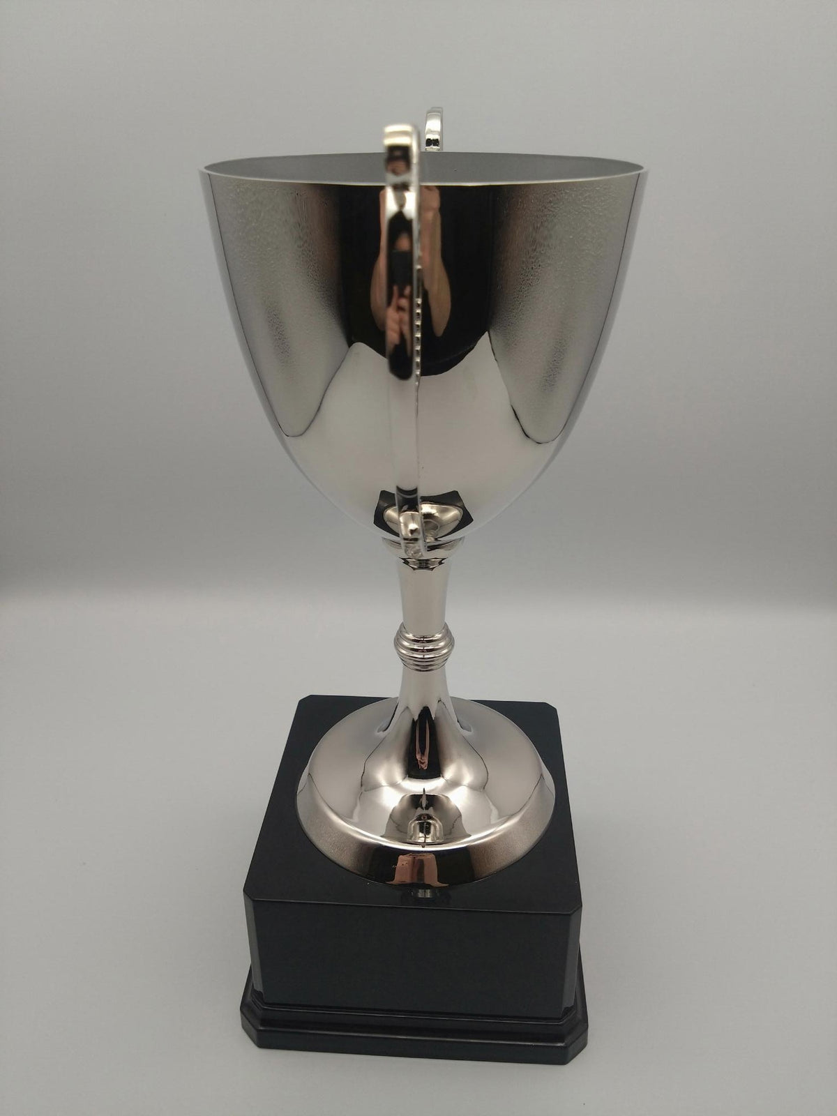 Silver trophy with a black base on a gray background