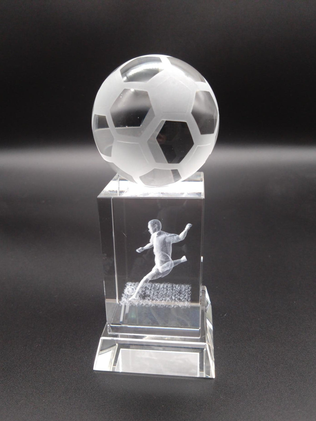 Crystal soccer ball and player figure on a dark background
