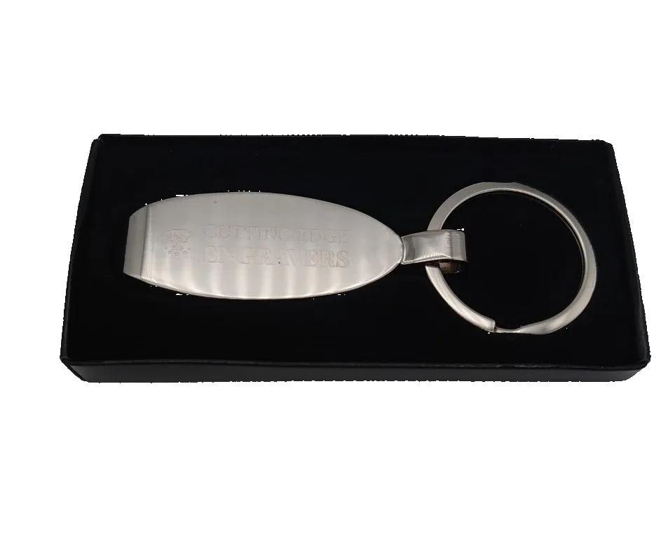 Silver keychain with engraved text on a black display box