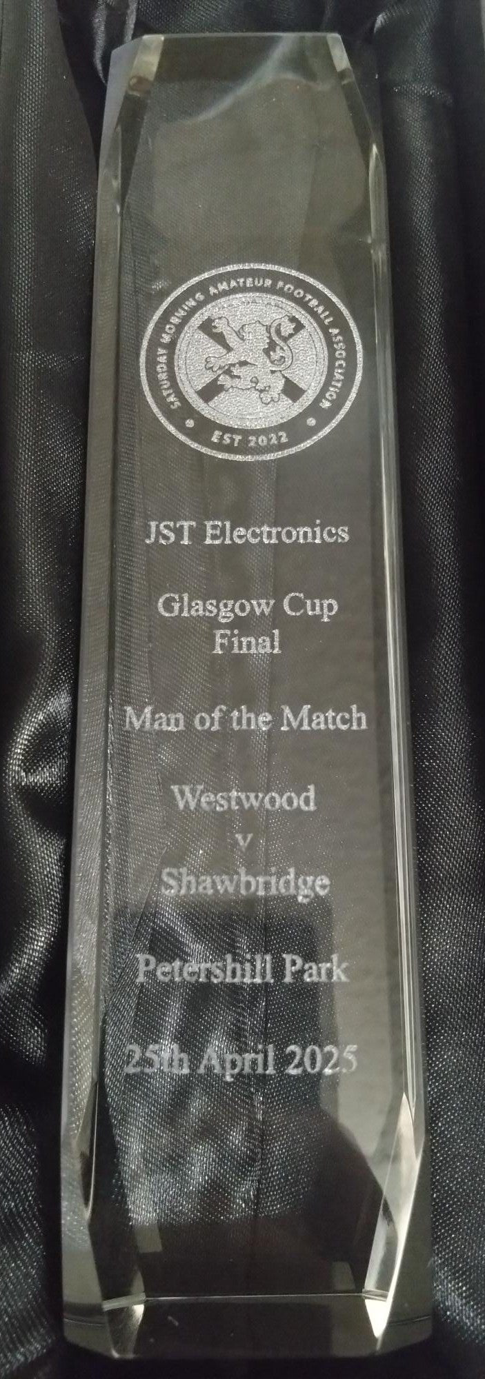 Crystal award with engraved text on a black background