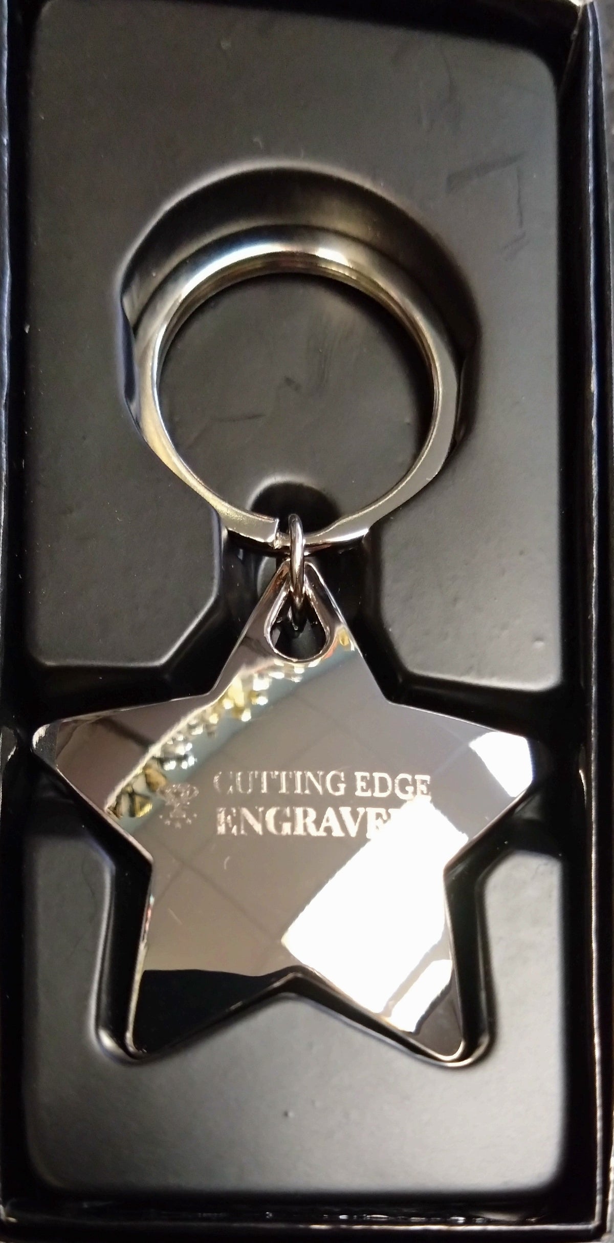 Star shaped keyring in a black gift box engraved with Cutting Edge Engravers logo