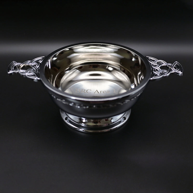 Silver quaich bowl with Celtic design on a black background