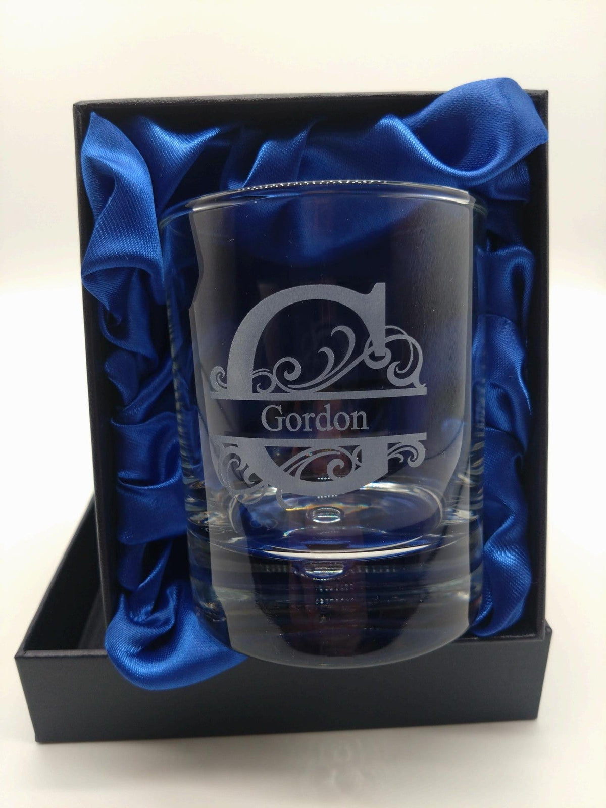 Glass with engraved design and 'Gordon' text, presented in a blue box with blue satin lining.