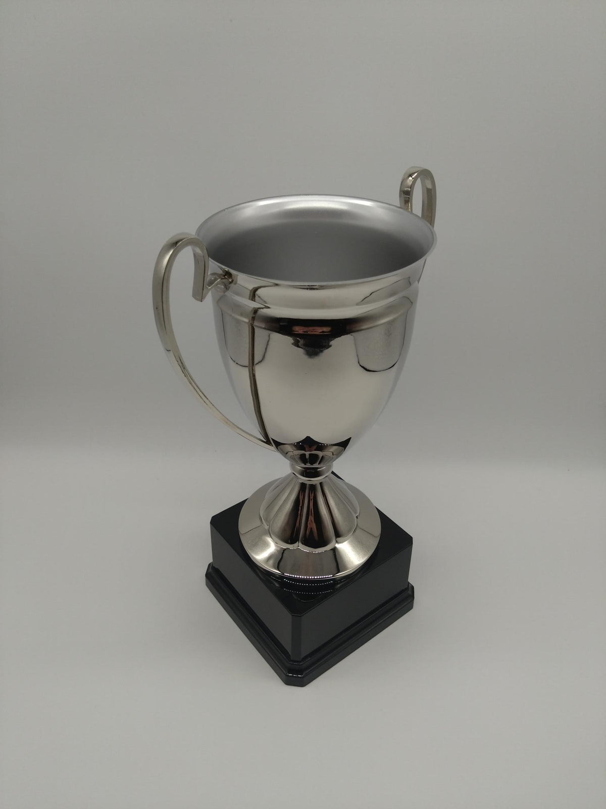 Silver trophy with a black base on a gray background