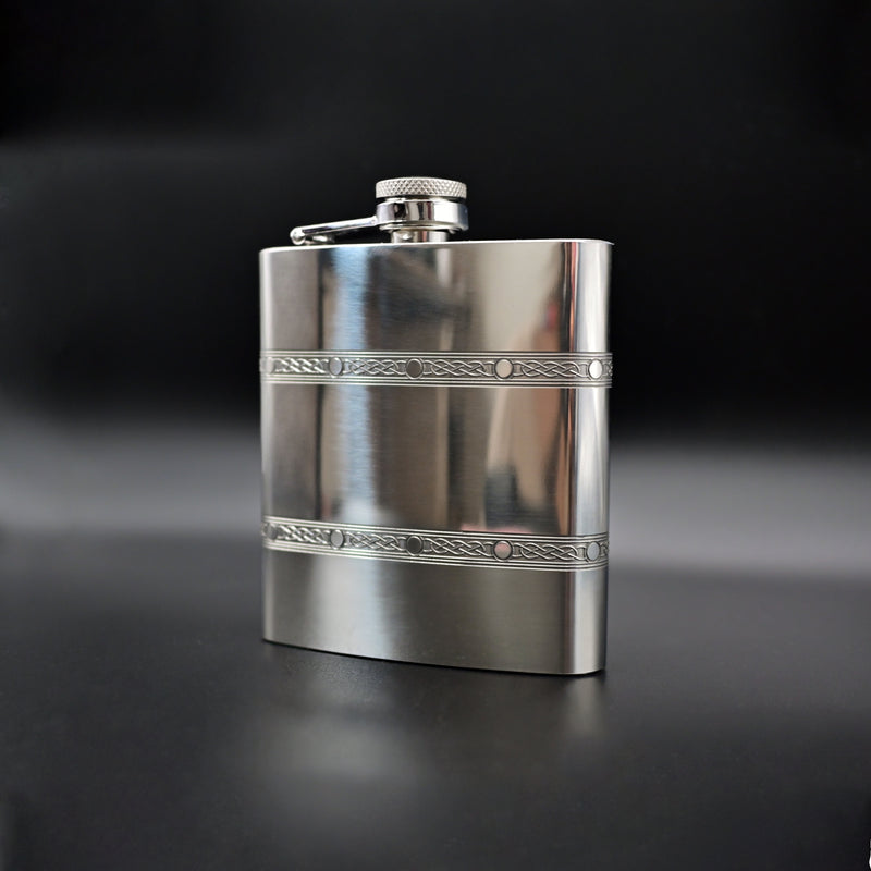 Silver flask with decorative band on a black background
