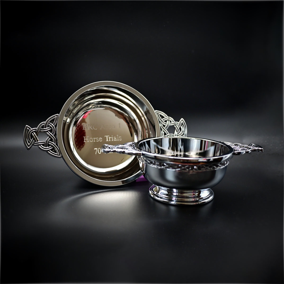 Silver decorative bowl and platter on a black background