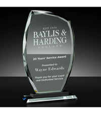 Glass award with engraved text on a black background