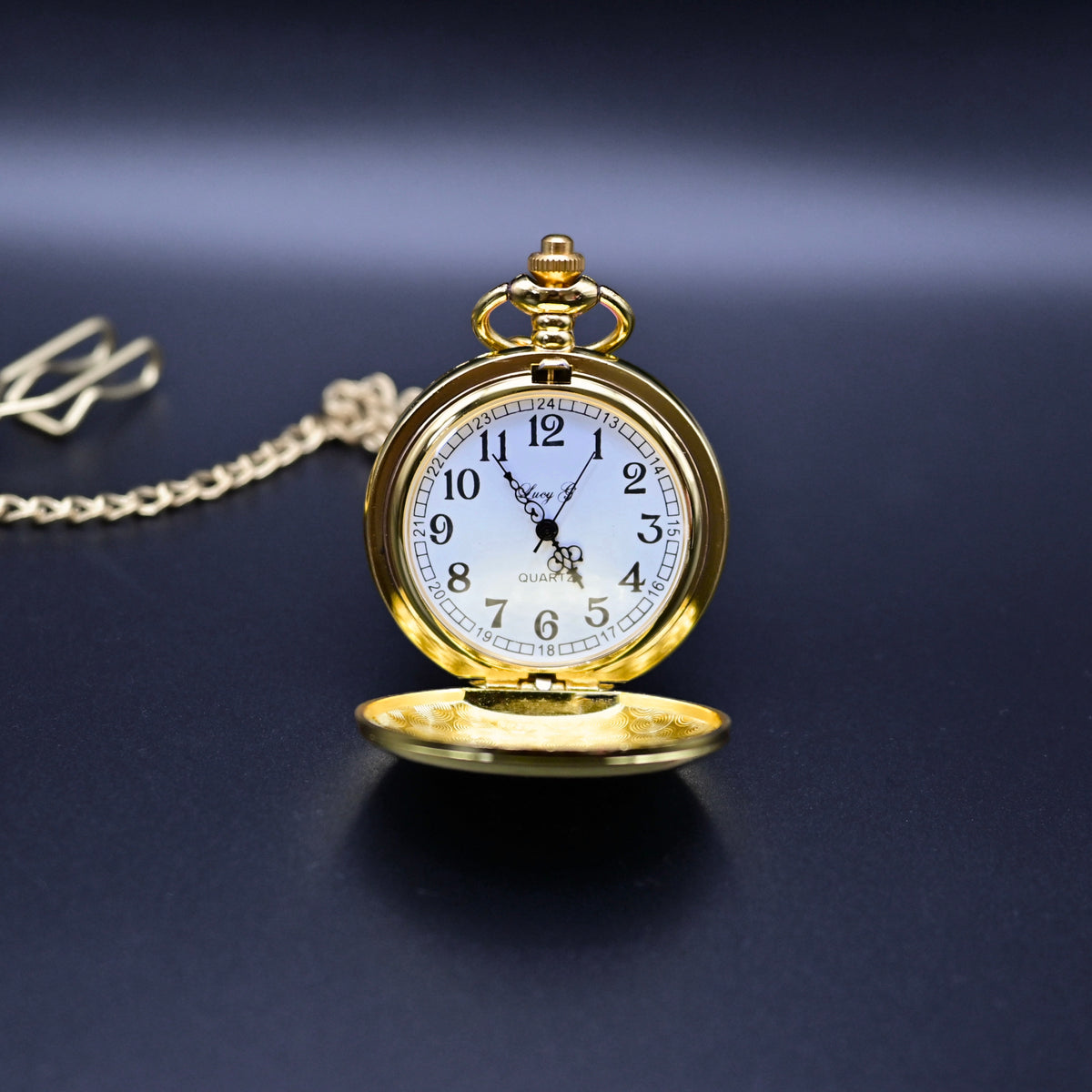 Gold pocket watch with a chain on a dark background