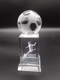 Crystal soccer ball and player figure on a dark background