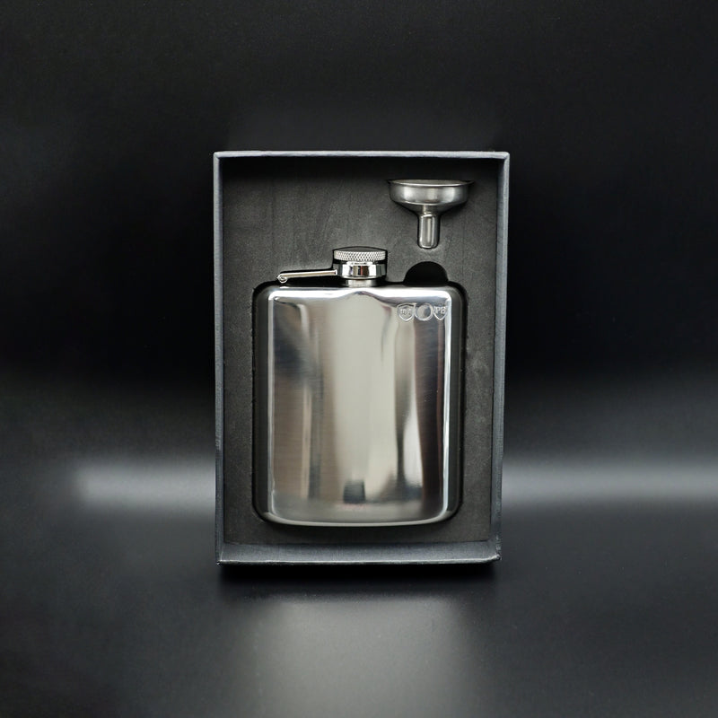 Silver flask with funnel in a black box on a dark background