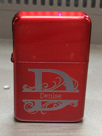 Red lighter with 'Denise' engraved on a metallic surface
